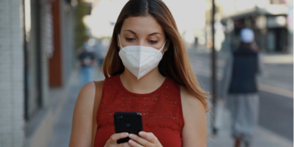 Woman wearing a mask using cell phone