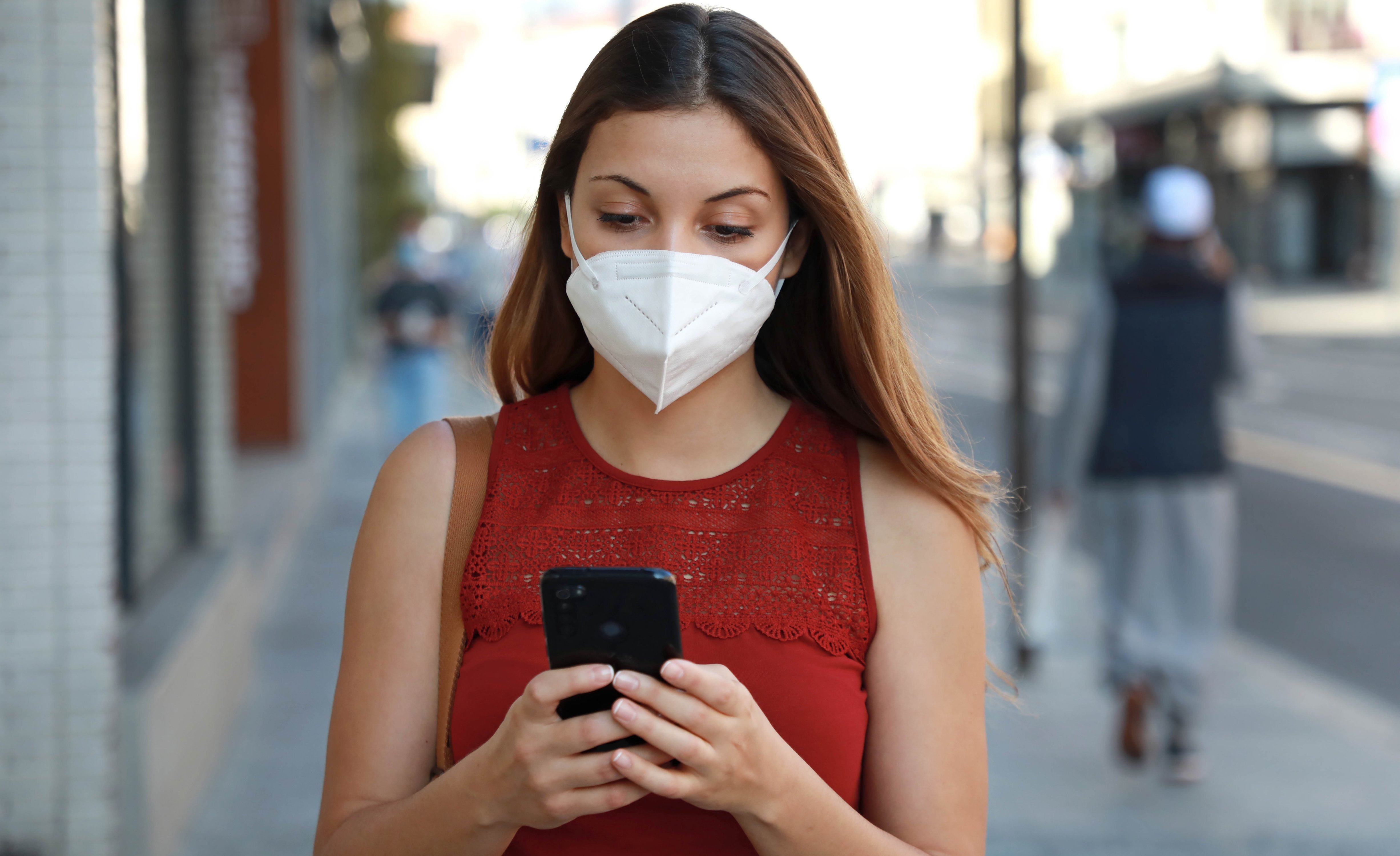 Woman wearing a mask using cell phone