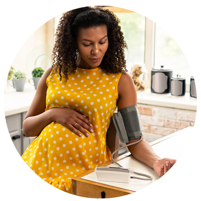Pregnant patient taking her blood pressure using BP cuff Pregnant patient taking her blood pressure using BP cuff